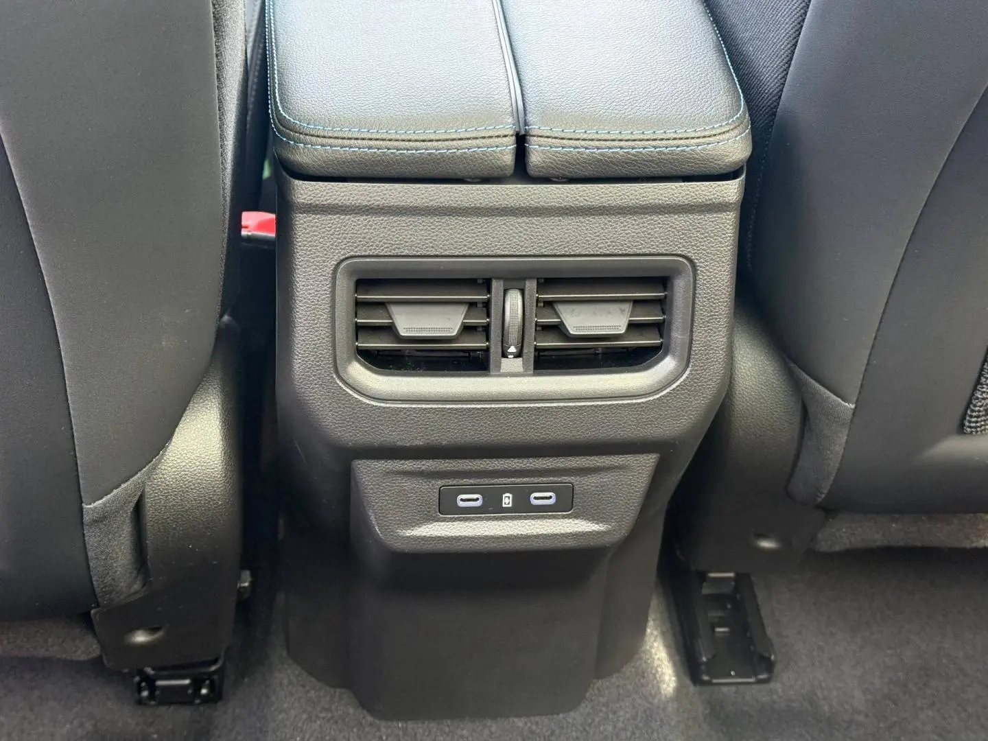 Vue rapprochée de la console arrière noire avec bouches d’aération et ports USB du Renault Austral gris Schiste satin.
