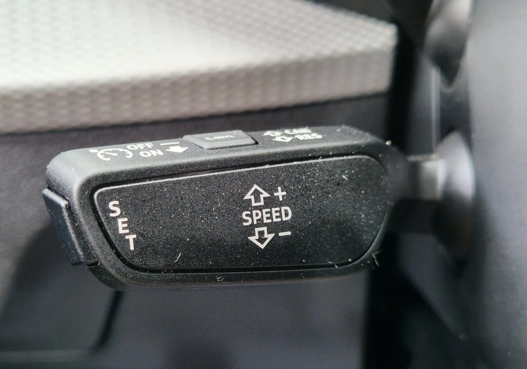 Gros plan sur la commande de régulateur de vitesse noir à l'intérieur de l'Audi Q2 35 TFSI 2023.