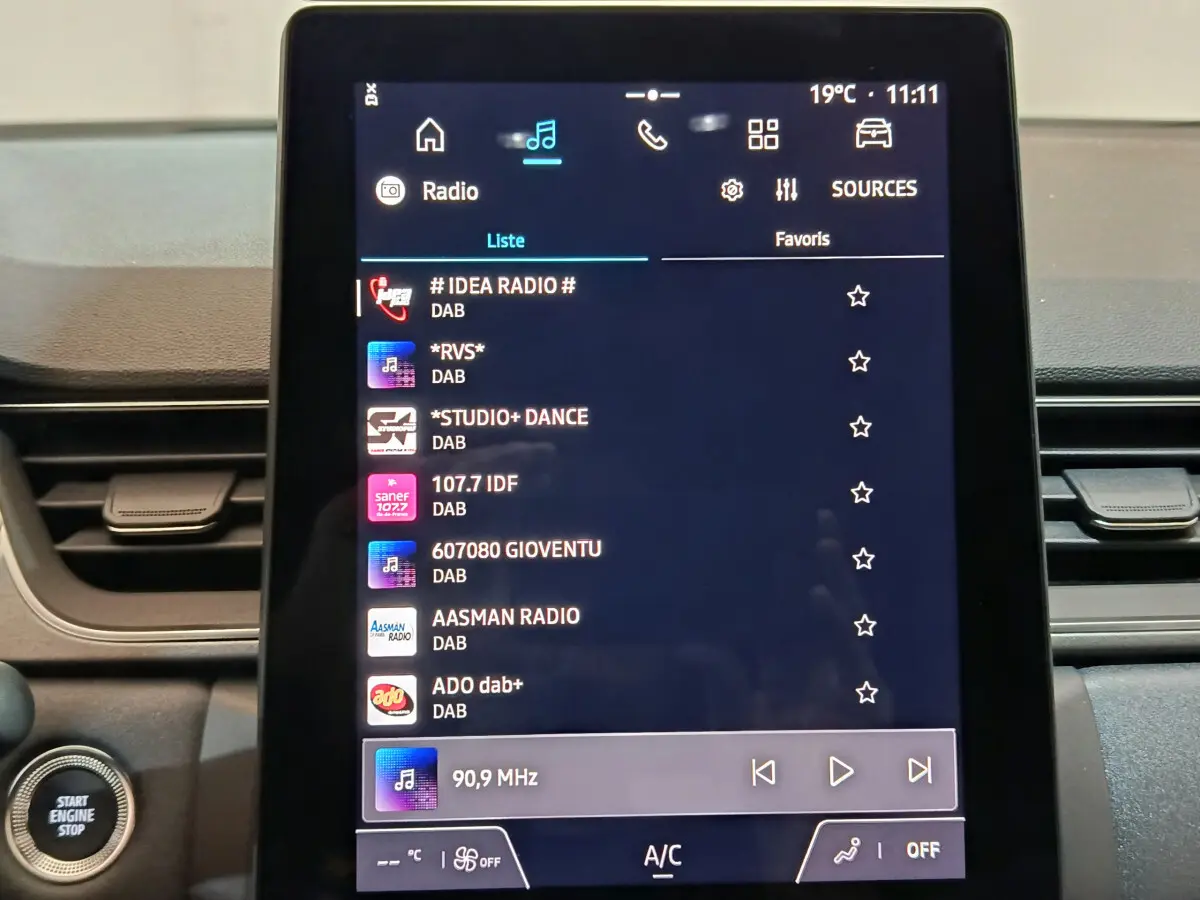 Écran tactile central affichant les radios DAB dans un Renault Captur blanc, vue rapprochée du tableau de bord.