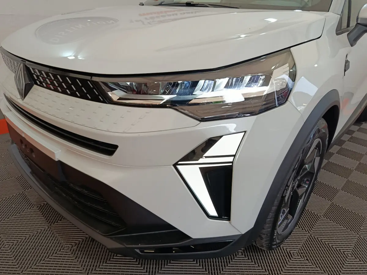 Gros plan sur l'avant droit du Renault Captur blanc 2025 avec phares LED et calandre moderne.