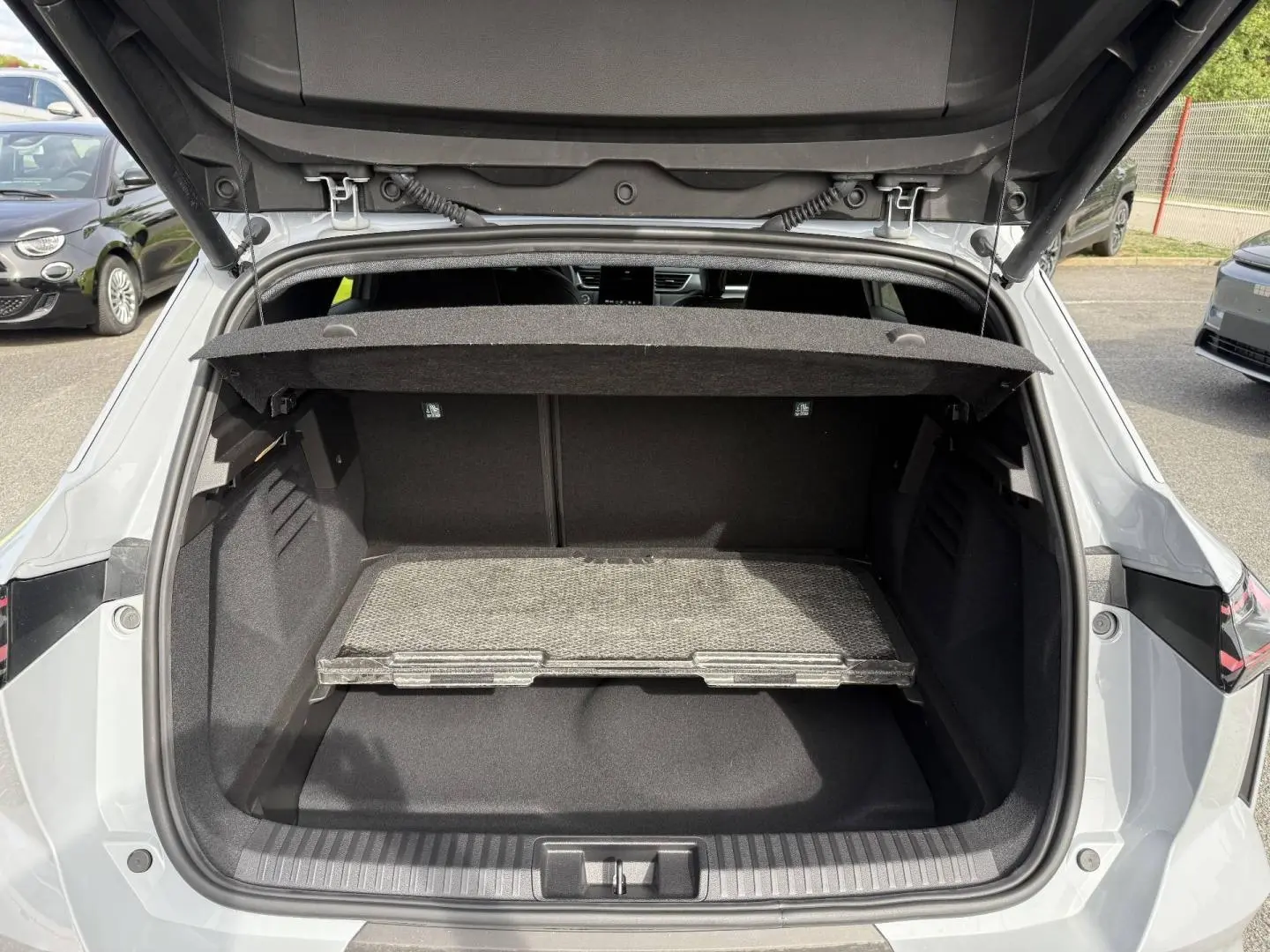 Coffre ouvert vu de l'arrière du Renault SYMBIOZ gris Rafale métallisé avec tablette de rangement amovible.
