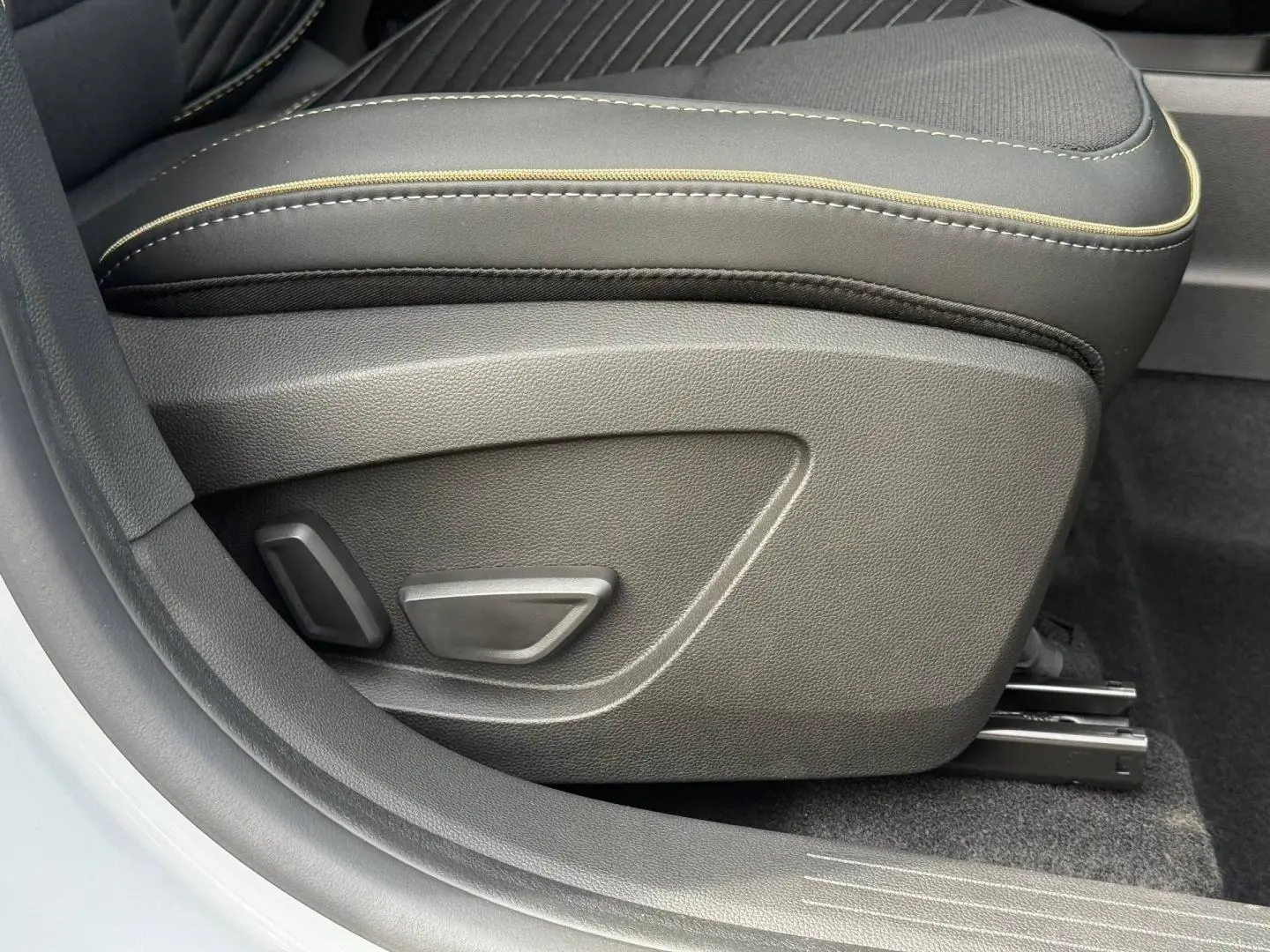 Détail du siège avant droit gris avec commandes électriques et surpiqûres contrastantes dans une Renault SYMBIOZ 2026.