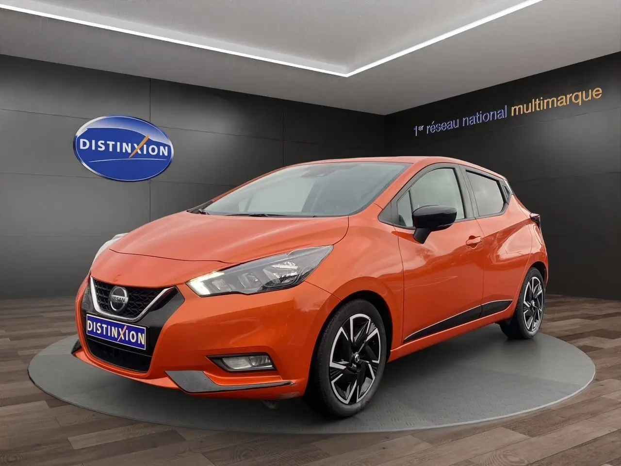 Nissan Micra 2022 orange Energy en 3/4 avant droit, avec jantes alliage noires et détails chromés.