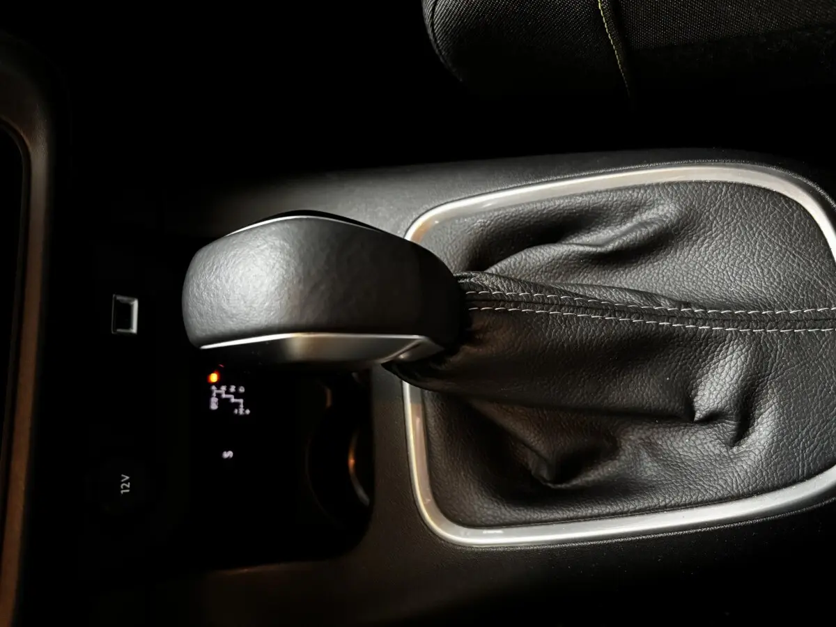 Gros plan sur le levier de vitesses automatique noir de la Citroën C3 PureTech 110 Shine, avec coutures visibles.