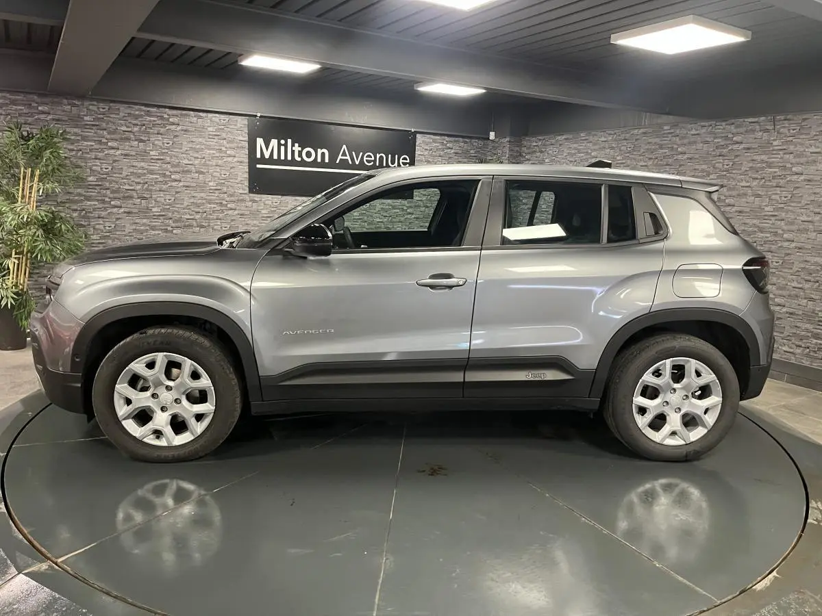 Profil côté gauche du Jeep Avenger gris métallisé 2024 avec jantes alliage et coques de rétroviseurs noires.