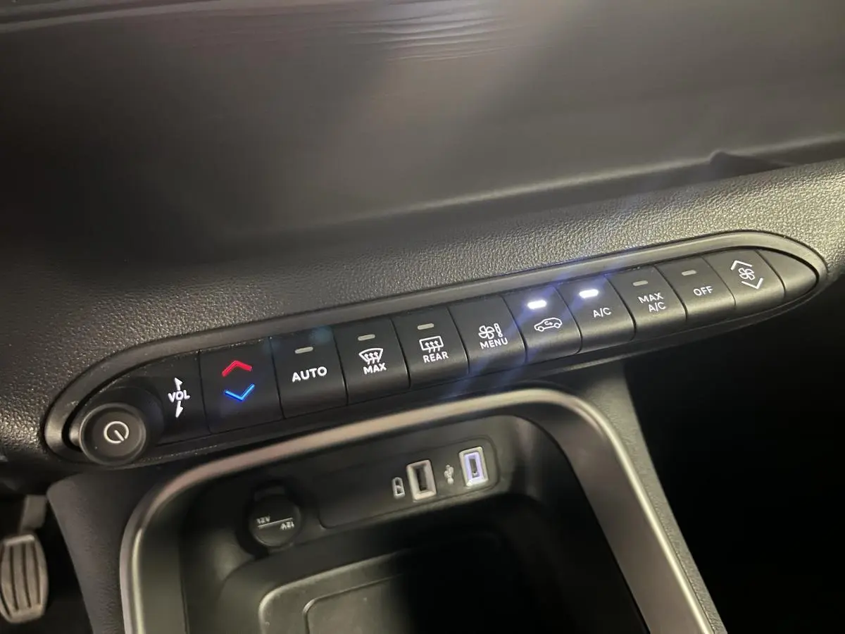 Gros plan sur la console centrale du Jeep Avenger 2024 montrant les commandes de climatisation et ports USB.