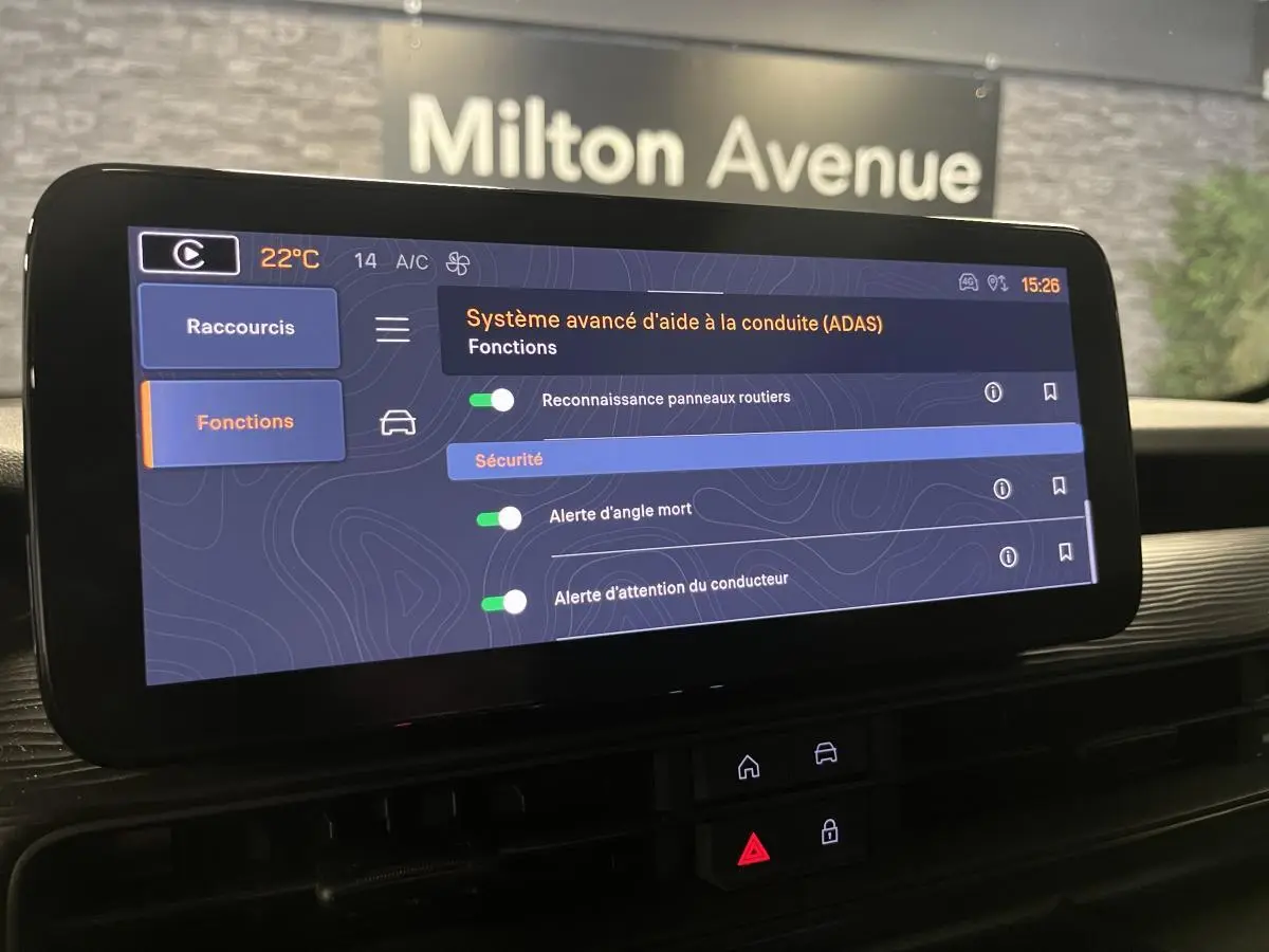 Écran tactile du système Uconnect affichant les aides à la conduite dans l'habitacle d'une Jeep Avenger 2024.