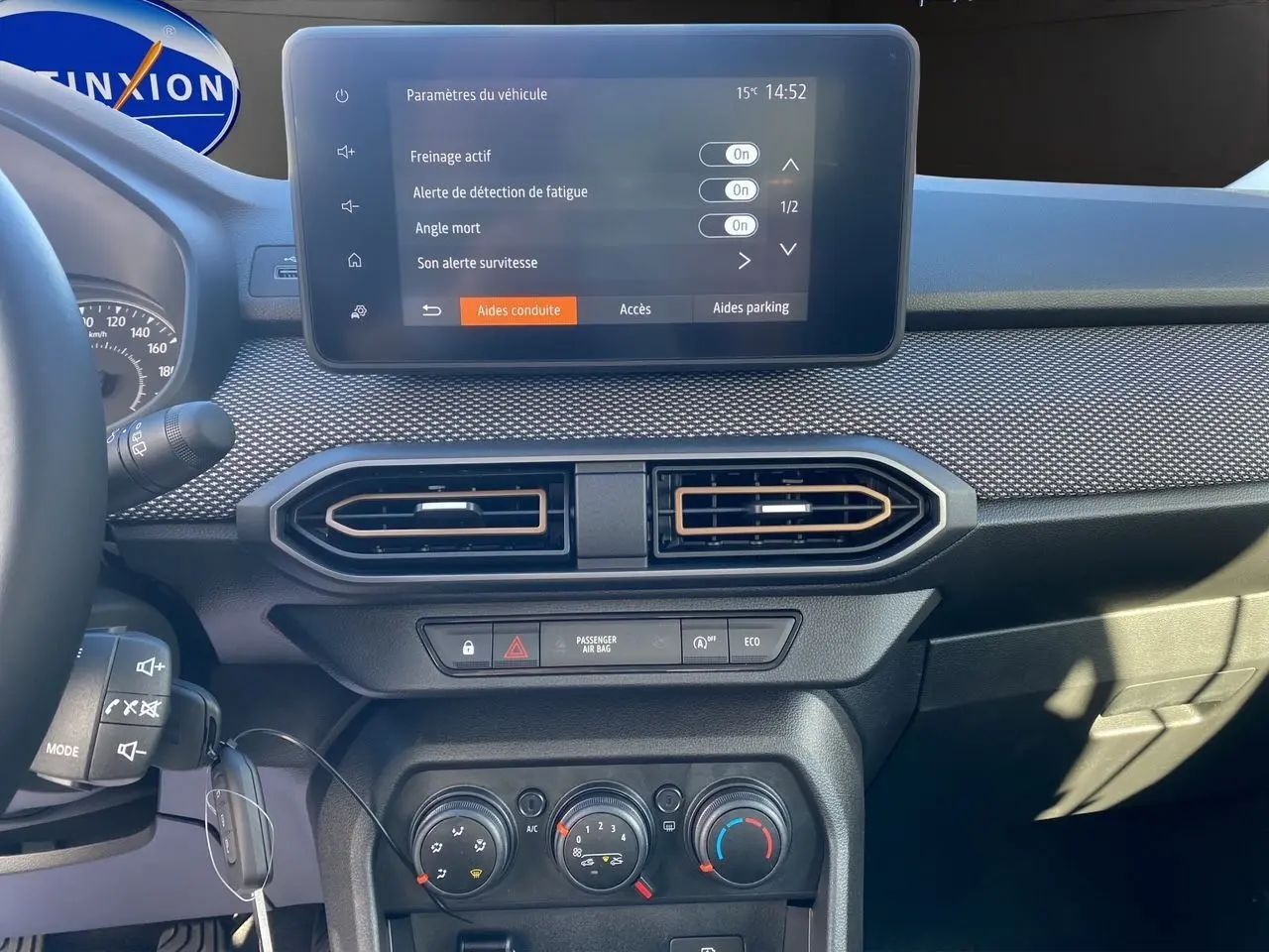 Vue rapprochée du tableau de bord noir de la Dacia Sandero Stepway 2025 avec écran tactile et commandes climatiques.