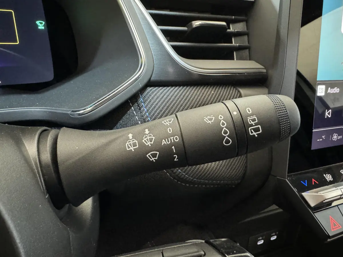 Gros plan sur la commande d’essuie-glace dans l’habitacle noir du Renault Captur blanc esprit Alpine E-Tech 2025.