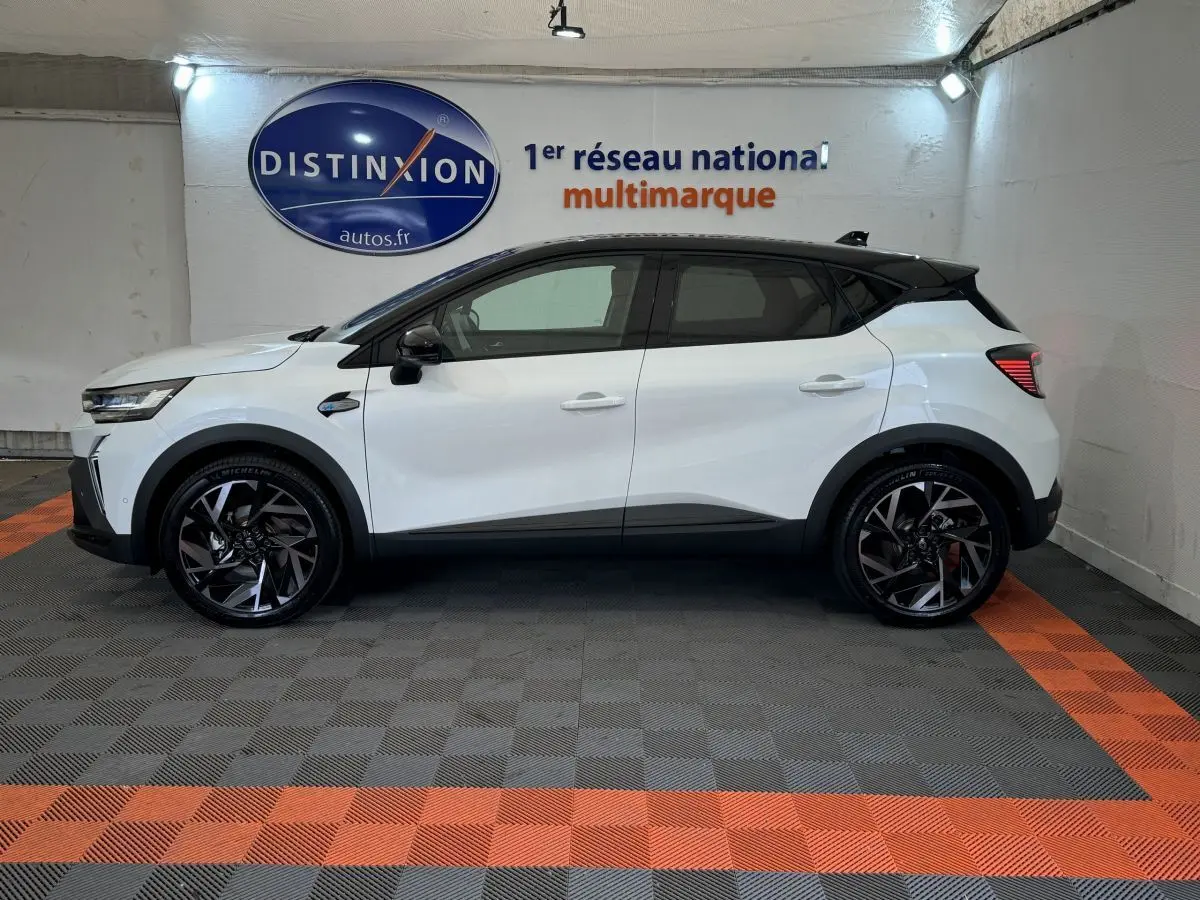 Profil gauche du Renault Captur blanc esprit Alpine E-Tech 145 hybride, avec jantes noires et toit noir contrastant.