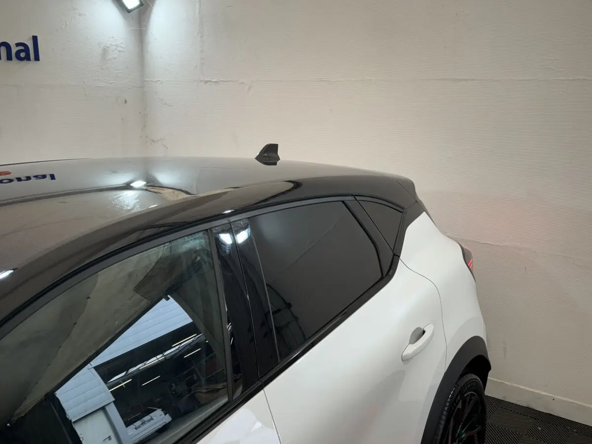 Vue arrière côté droit du Renault Captur blanc esprit Alpine E-Tech avec toit noir et vitres teintées.