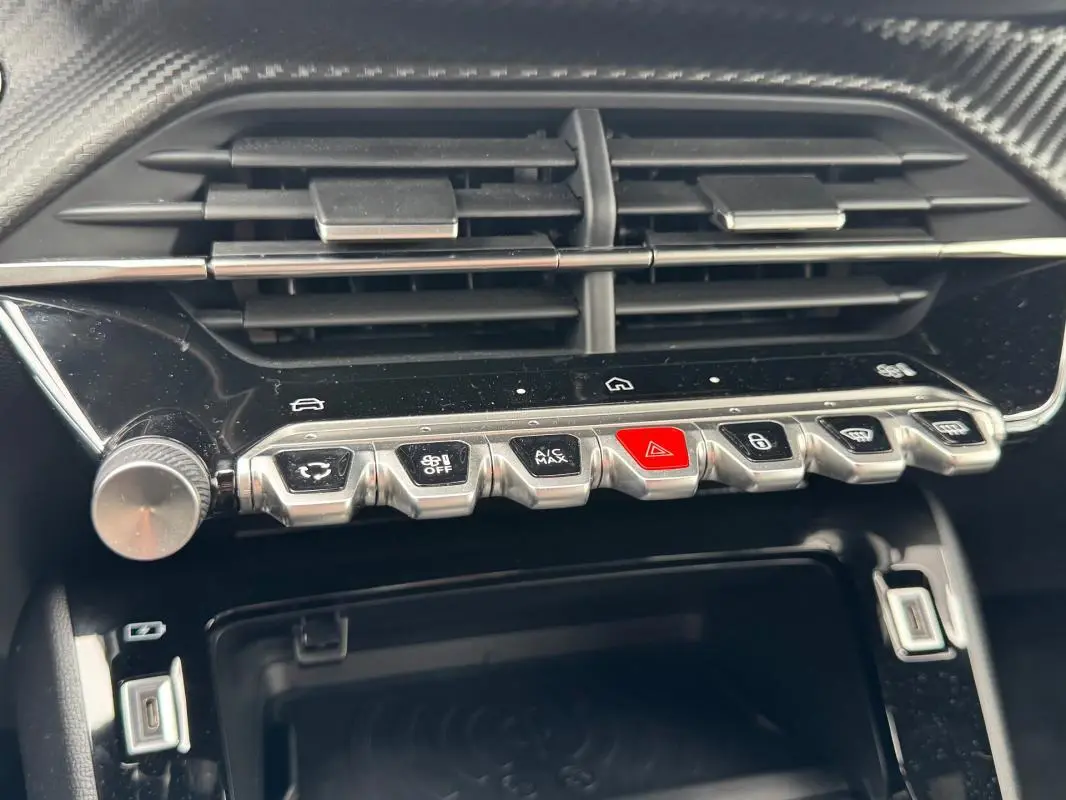 Gros plan sur la console centrale de la Peugeot 208 Hybrid 110 e-DCS6 GT 2025, montrant les boutons de commande et la prise USB.