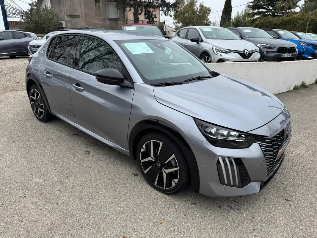 Peugeot 208 Hybrid gris vue 3/4 avant droit, jantes alliage 17 pouces et rétroviseurs noirs visibles.