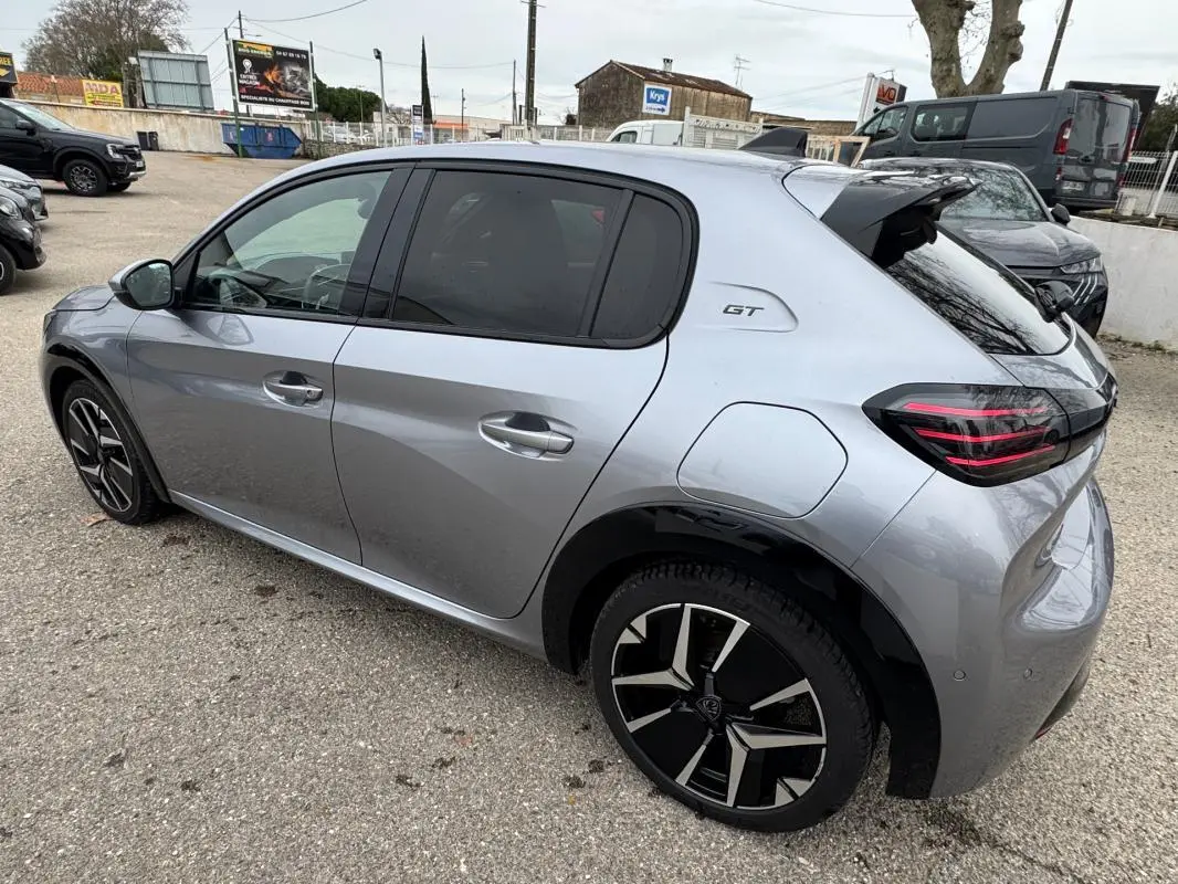 Vue 3/4 arrière droite d'une Peugeot 208 Hybrid 110 gris métallisé avec jantes alliage 17 pouces et badge GT.