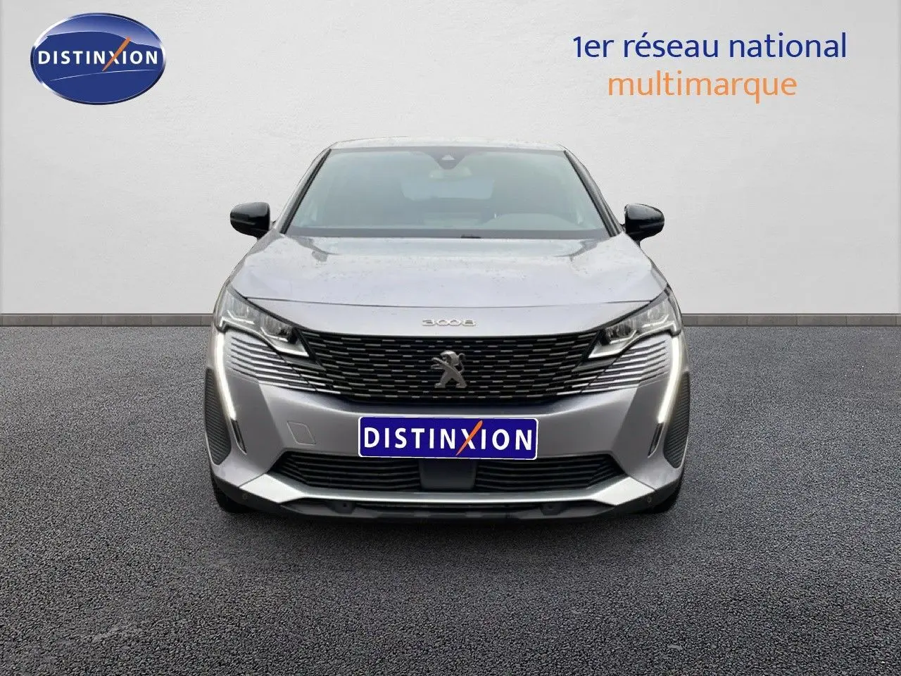 Vue frontale d'un Peugeot 3008 gris Artense métal 2024 avec calandre noire et feux LED verticaux allumés.