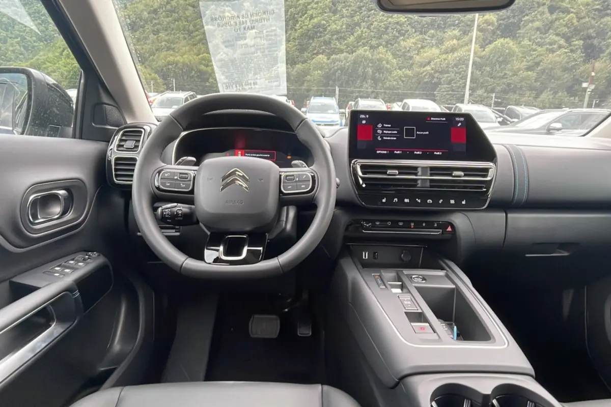 Intérieur du Citroën C5 Aircross Hybrid 2025 vu de face, avec tableau de bord noir et écran tactile central.