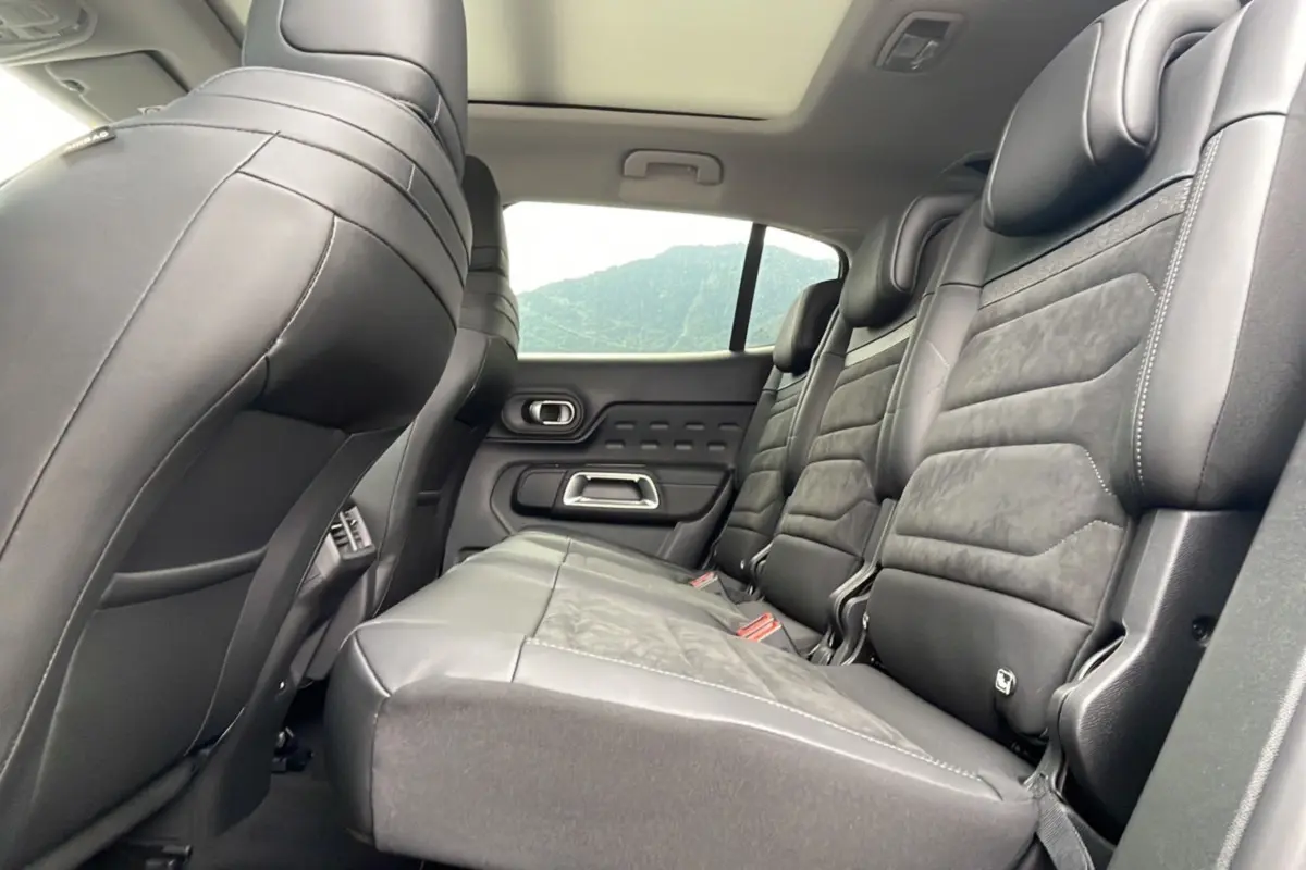 Vue latérale droite de l'intérieur arrière du Citroën C5 Aircross 2025, sièges en cuir noir avec surpiqûres apparentes.
