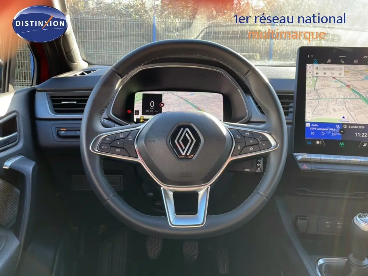 Vue intérieure centrée sur le volant Renault Captur 2025, avec tableau de bord numérique et écran tactile GPS visible.