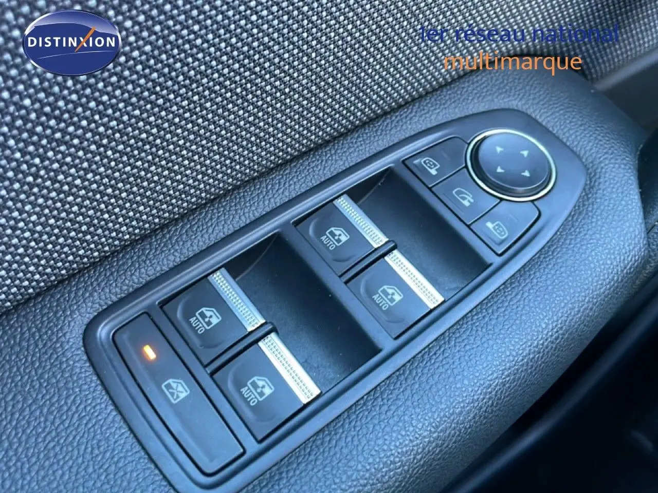 Vue rapprochée des commandes de lève-vitres côté conducteur d’un Renault Captur rouge Désir Métal avec toit noir.