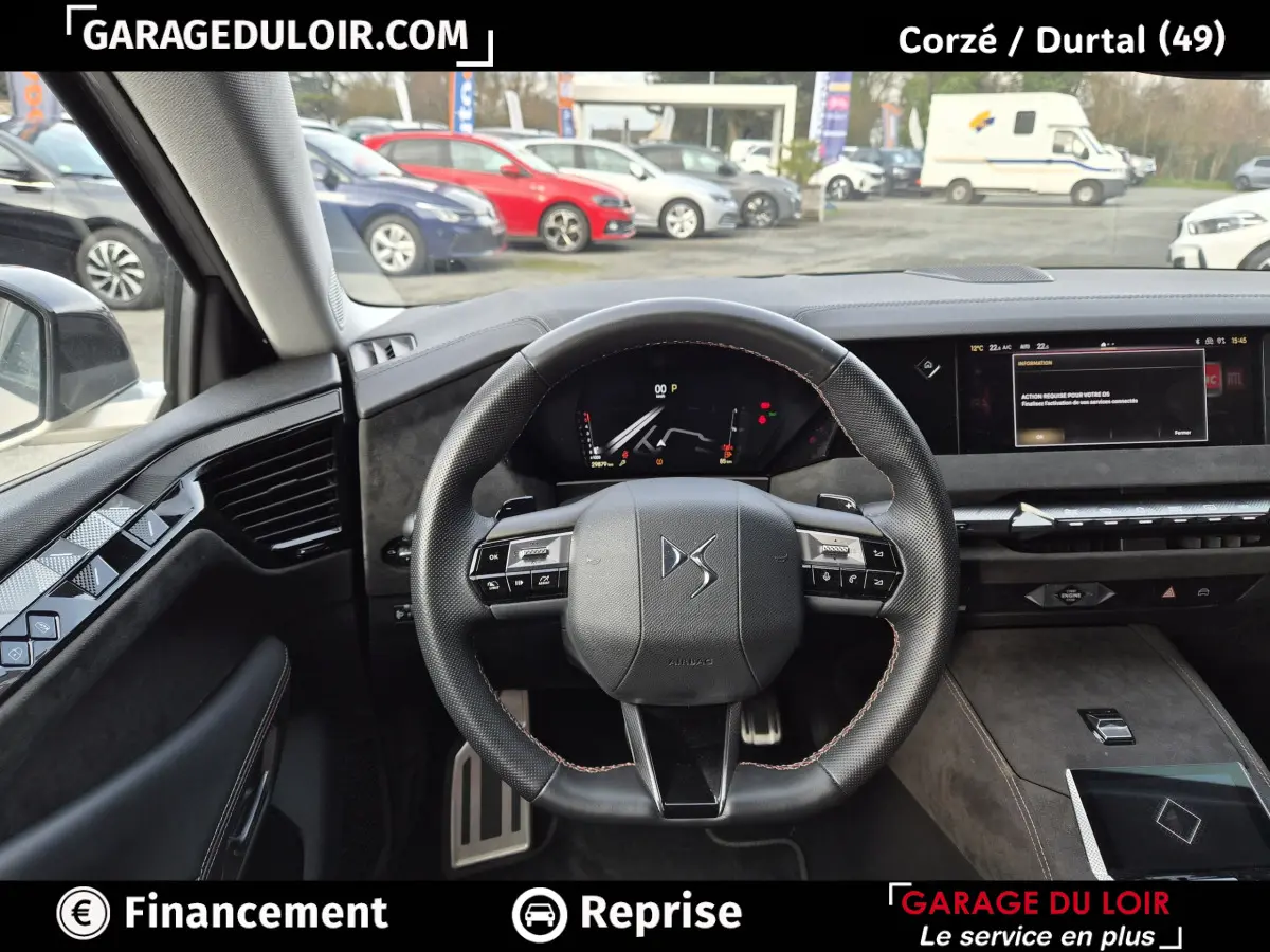 Vue intérieure du poste de conduite du DS4 2024 beige, volant cuir multifonctions et écran tactile central visible.