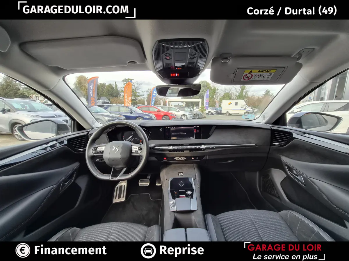 Vue intérieure avant du tableau de bord et volant cuir noir du DS4 beige avec écran tactile central et commandes modernes.