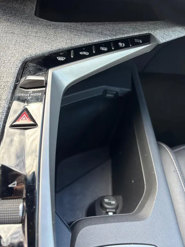 Vue rapprochée de la console centrale du Peugeot 3008 Hybrid 145 e-DCS6 Allure 2025, avec boutons de commandes et prise 12V.