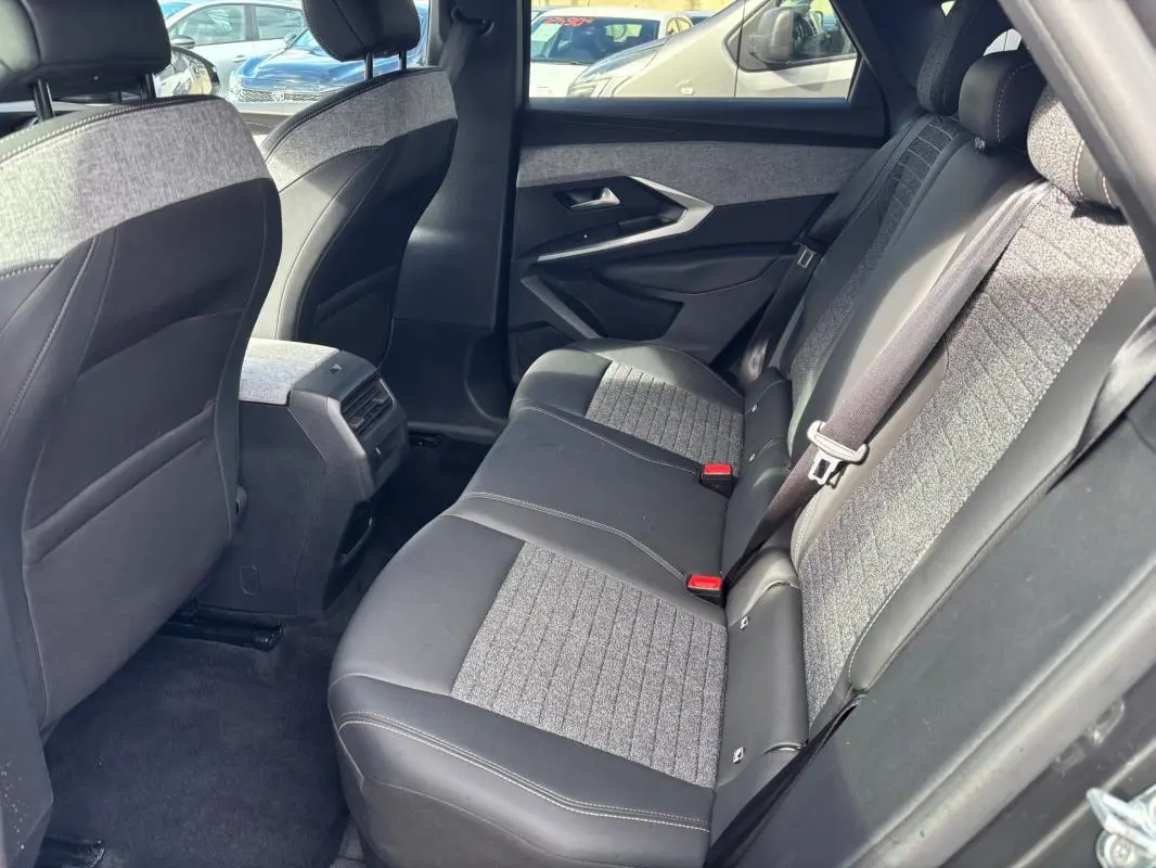 Vue intérieure arrière côté droit du Peugeot 3008 Hybrid 145 e-DCS6 Allure 2025, sièges bi-matière gris et noir.