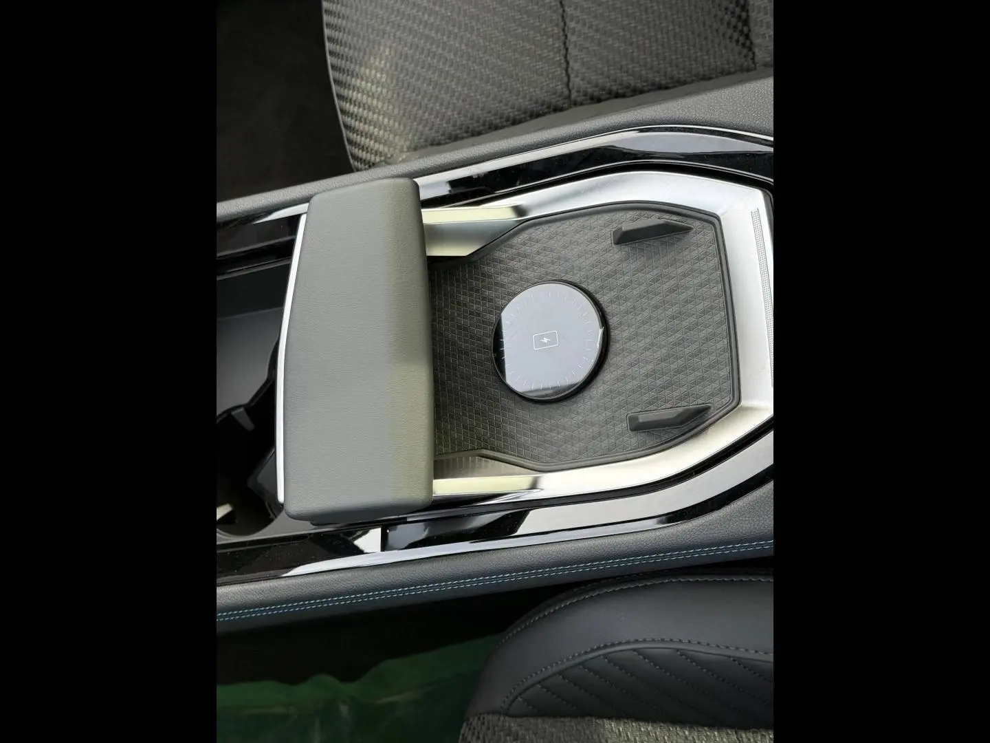Détail de la console centrale noire avec accoudoir gris et surface de recharge sans fil du Renault Austral 2026.