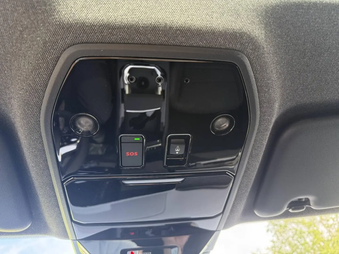 Vue en contre-plongée du panneau de commande intérieur noir brillant avec bouton SOS rouge et éclairage intégré sur Renault Austral 2026.