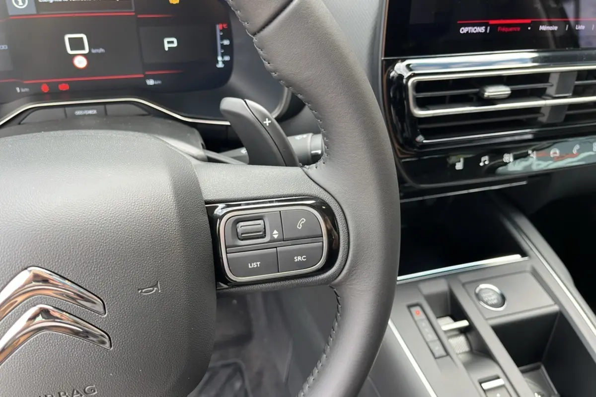Intérieur du Citroën C5 Aircross Hybrid 2025, vue sur le volant avec commandes et tableau de bord numérique.