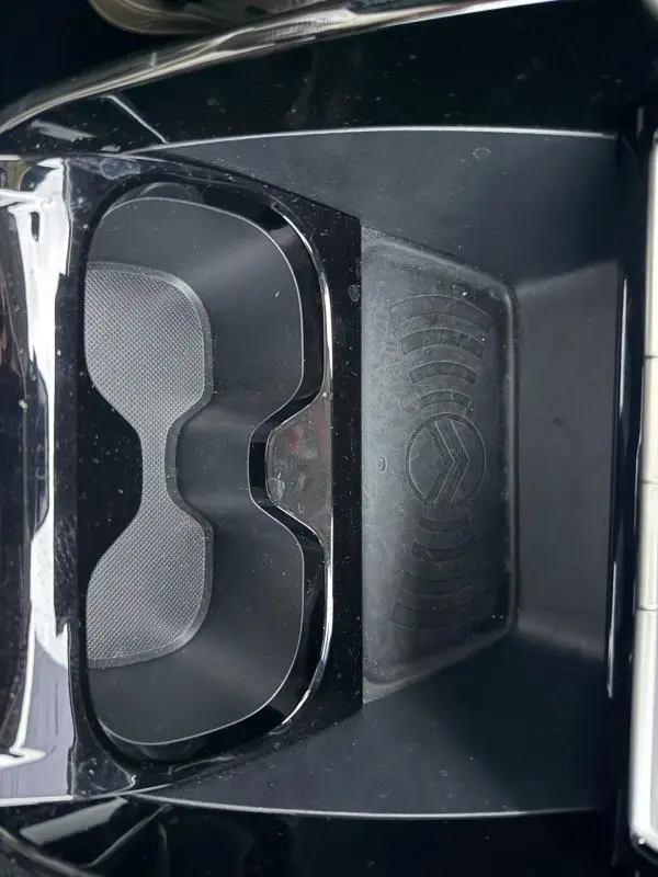 Gros plan sur le porte-gobelets noir avec logo Citroën en relief dans l'habitacle de la Citroën C3 gris.