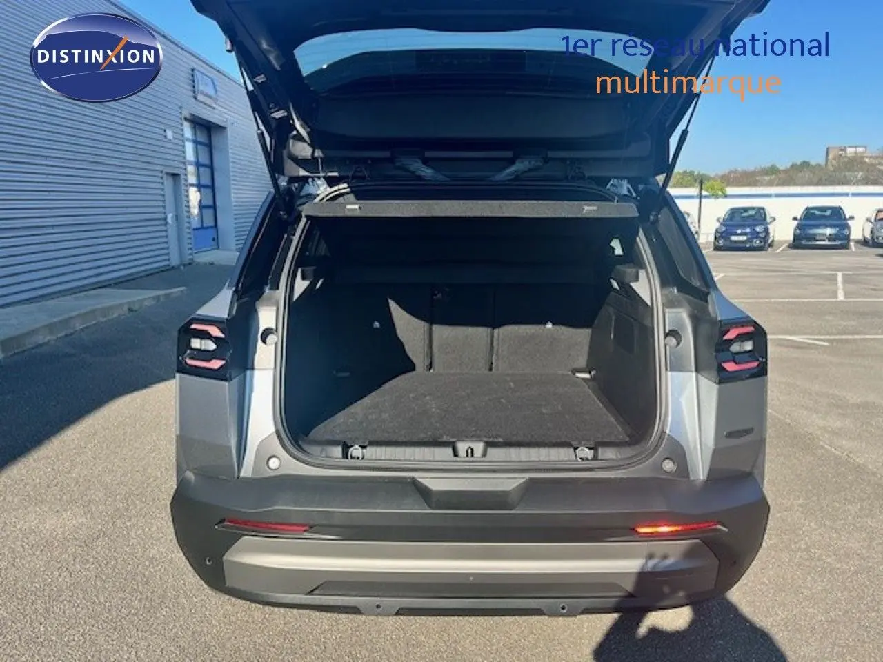 Vue arrière ouverte du Jeep Compass gris Yosemite métal avec coffre spacieux et toit noir visible en extérieur.