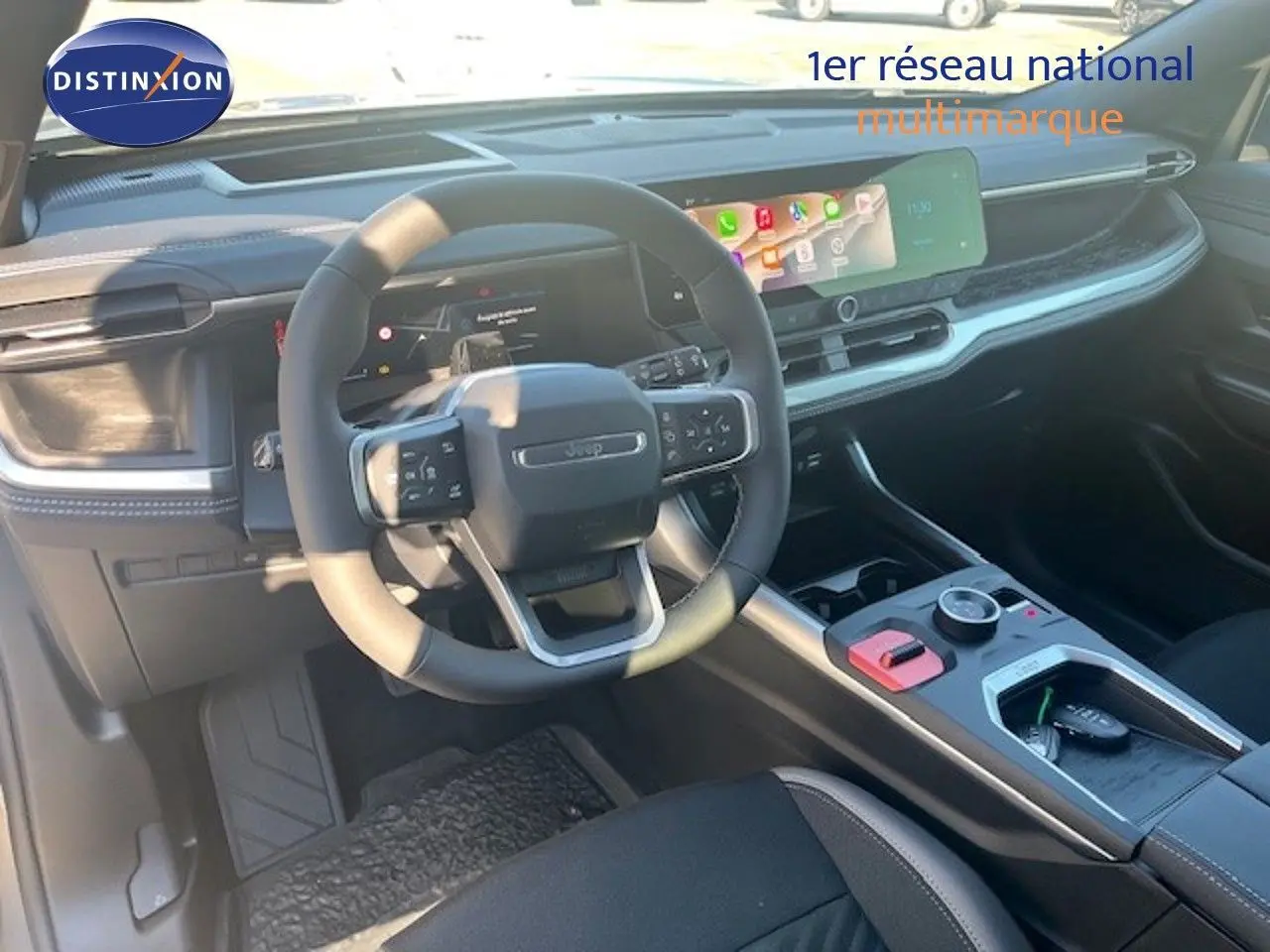 Vue intérieure du poste de conduite du Jeep Compass 2026, volant multifonction et écran tactile large, ambiance noire moderne.