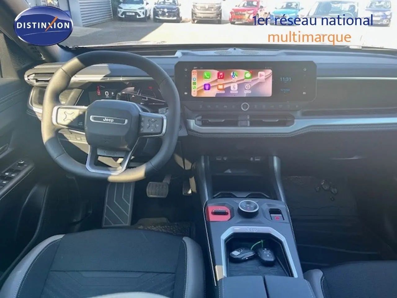 Intérieur Jeep Compass 2026 vue avant, tableau de bord noir avec écran tactile large et volant multifonction cuir.