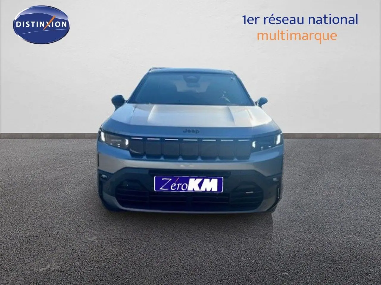 Vue frontale du Jeep Compass 2026 gris Yosemite métal avec toit noir, mettant en valeur sa calandre distinctive et ses phares LED.