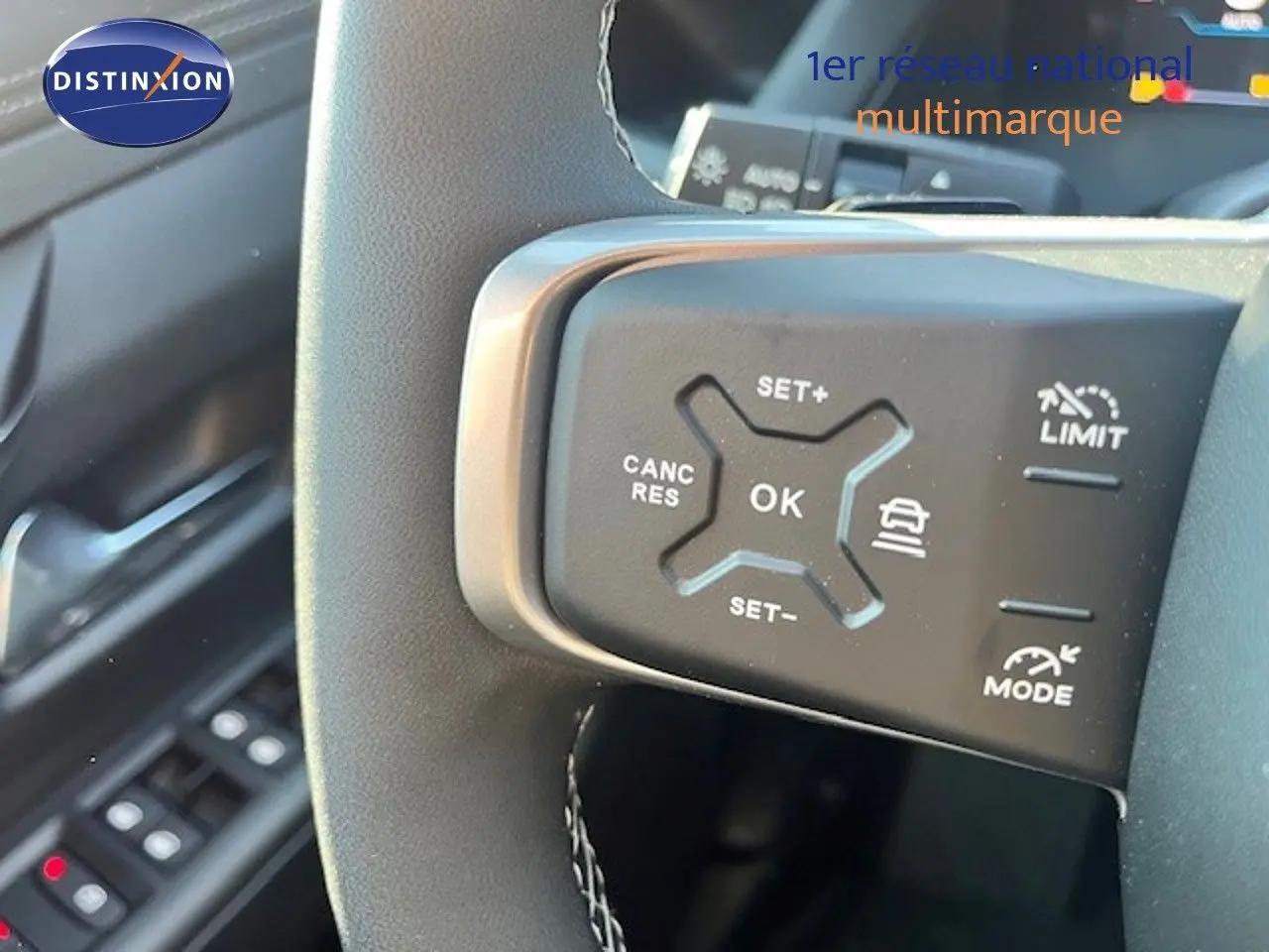 Gros plan sur les commandes de régulateur de vitesse au volant d’un Jeep Compass 2026 gris Yosemite métal avec toit noir.