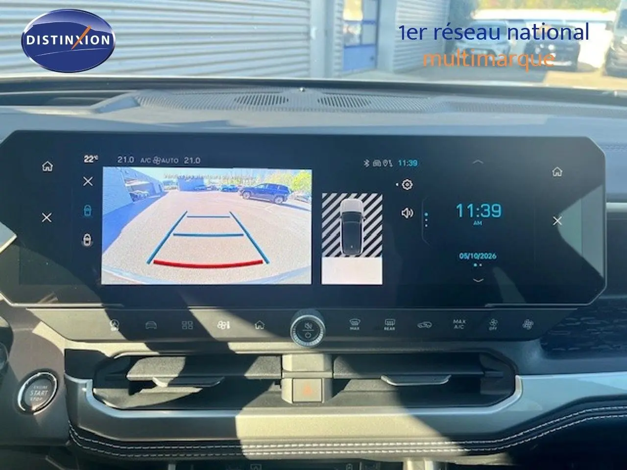 Vue intérieure du tableau de bord du Jeep Compass 2026, écran tactile affichant la caméra de recul et l'heure, ambiance moderne.
