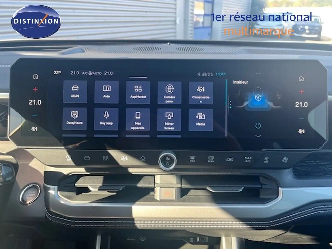 Vue intérieure du tableau de bord du Jeep Compass 2026, écran tactile large affichant les commandes de climatisation et multimédia.