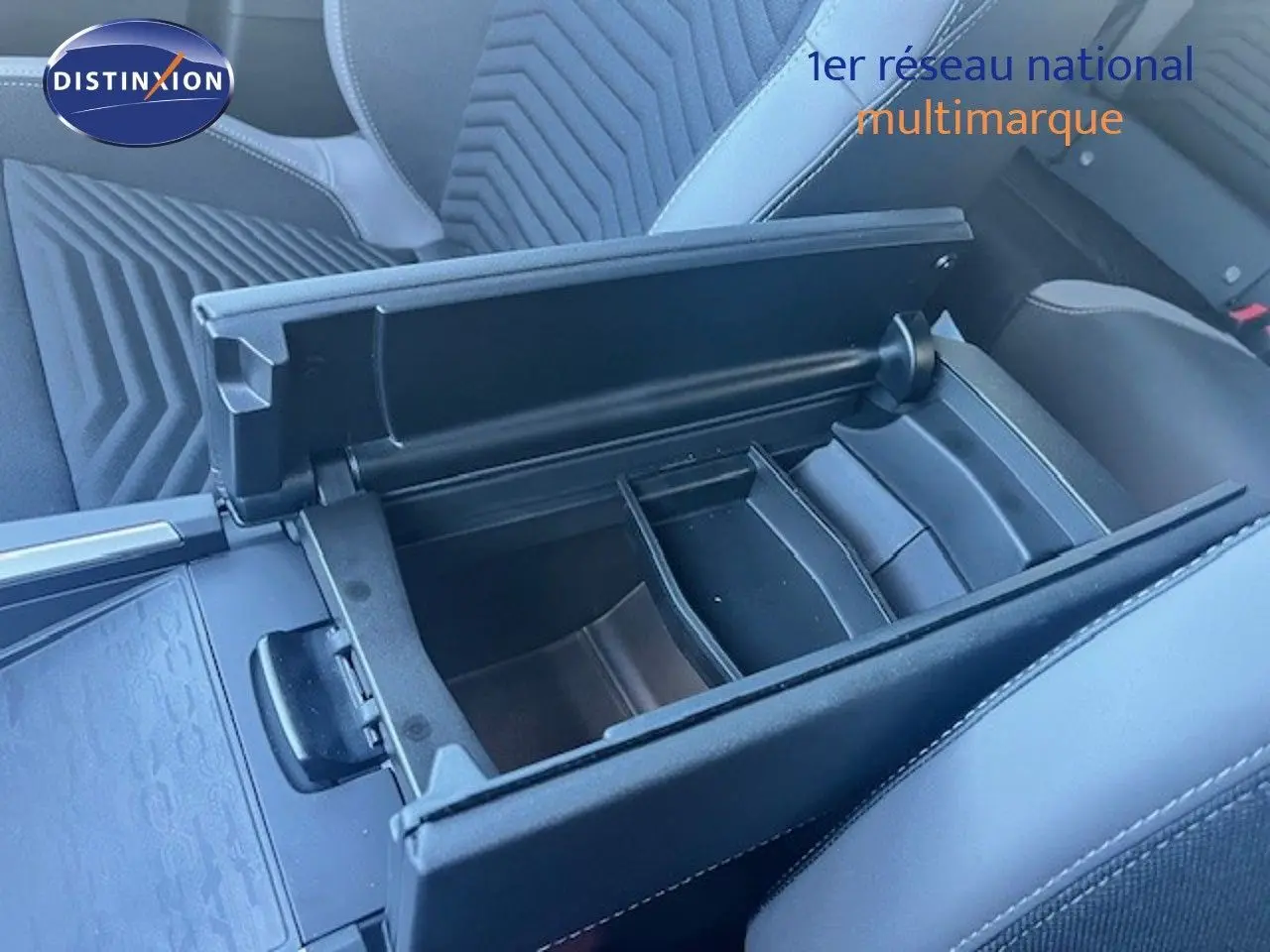 Vue rapprochée de l'accoudoir central ouvert et compartimenté dans l'habitacle noir du Jeep Compass 2026.