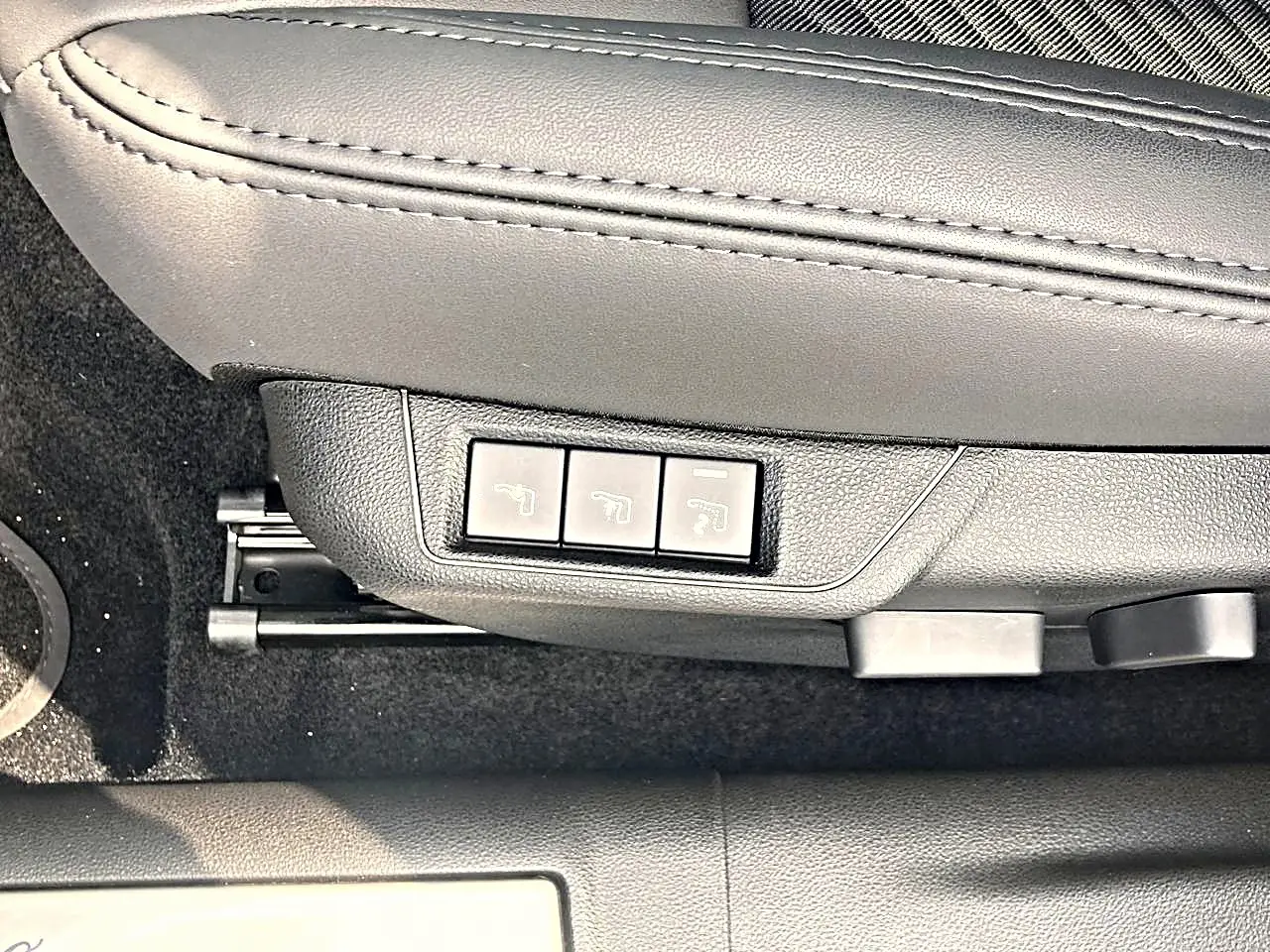 Gros plan sur les commandes électriques du siège conducteur en cuir noir de l'Alfa Romeo Junior gris 2026.