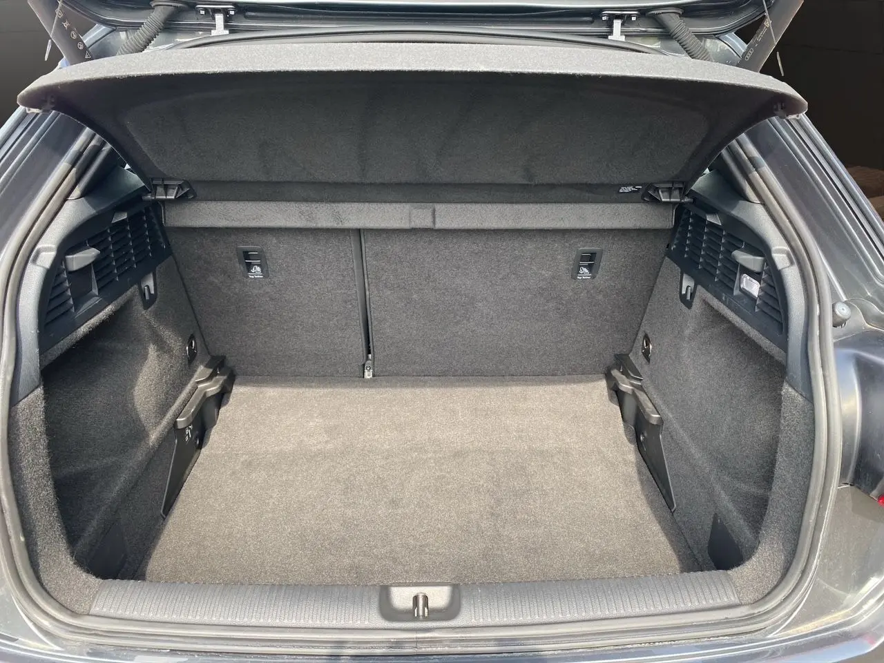 Coffre ouvert vu de l'arrière d'un Audi Q2 35 TDI S-Line gris Daytona avec hayon électrique.