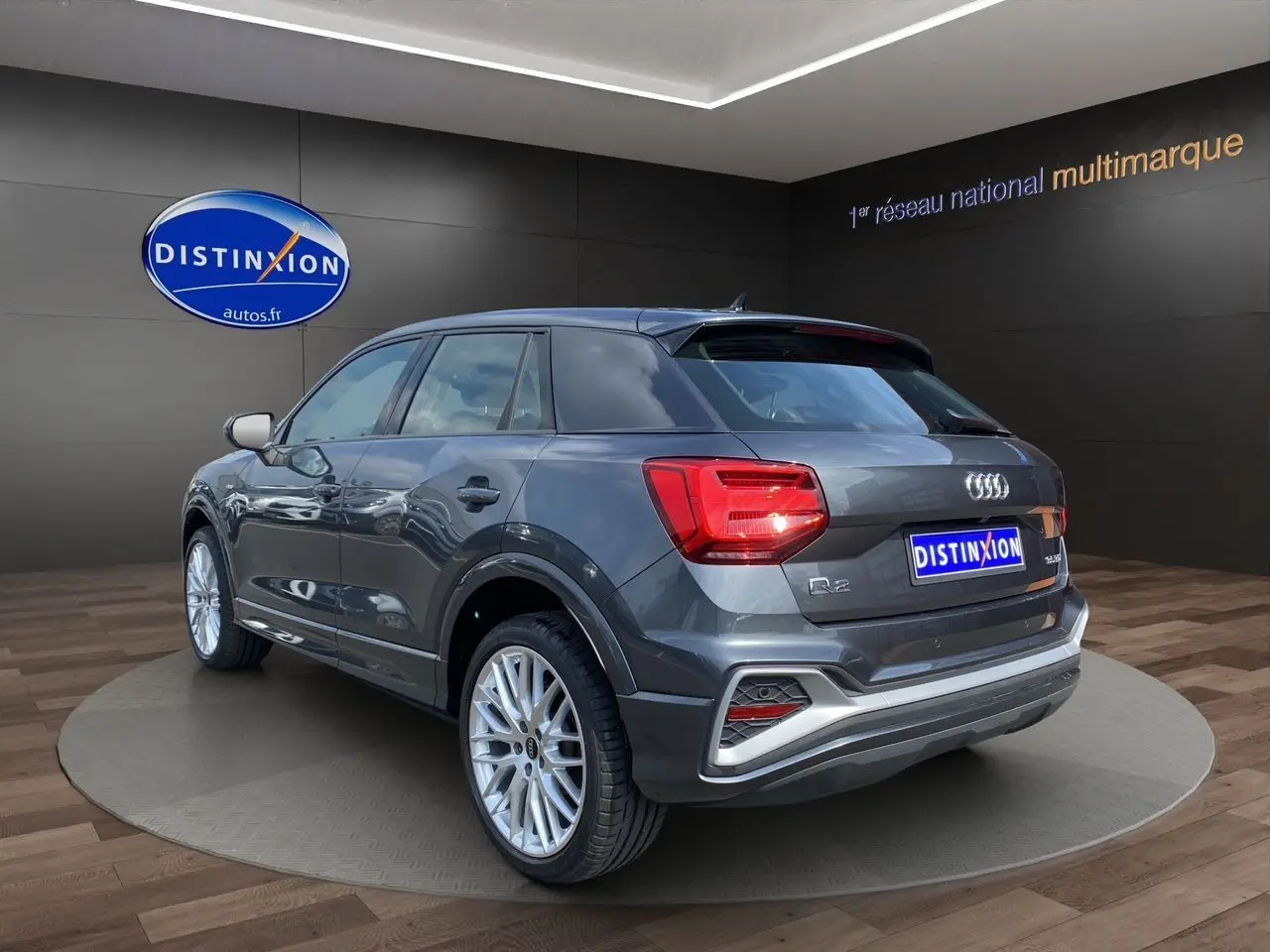 Audi Q2 gris Daytona en 3/4 arrière droit, avec jantes aluminium 19 pouces et feux arrière LED distinctifs.