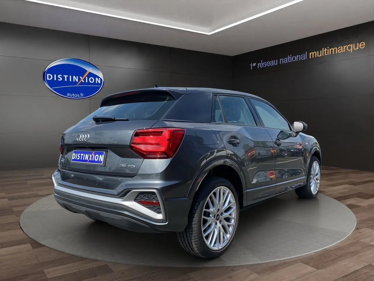 Audi Q2 gris Daytona en 3/4 arrière droit, avec feux LED et jantes aluminium Audi Sport 19 pouces visibles.