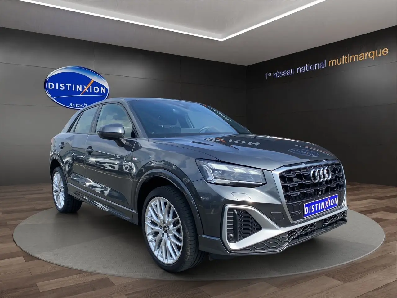 Audi Q2 gris Daytona en 3/4 avant droit, avec jantes aluminium Audi Sport et calandre noire S line.