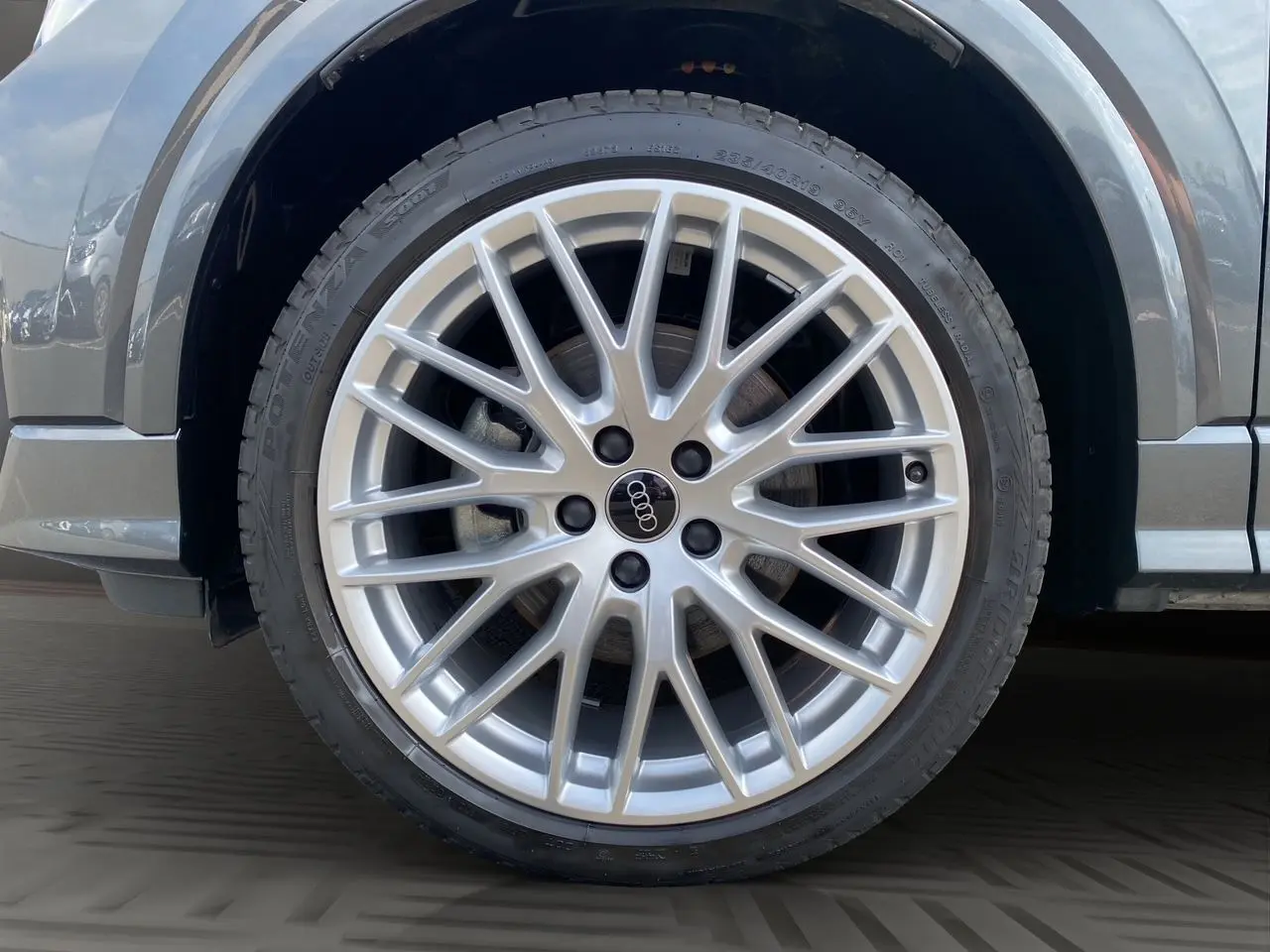 Gros plan sur la jante aluminium Audi Sport 19 pouces en Y du côté avant droit du Q2 gris Daytona.