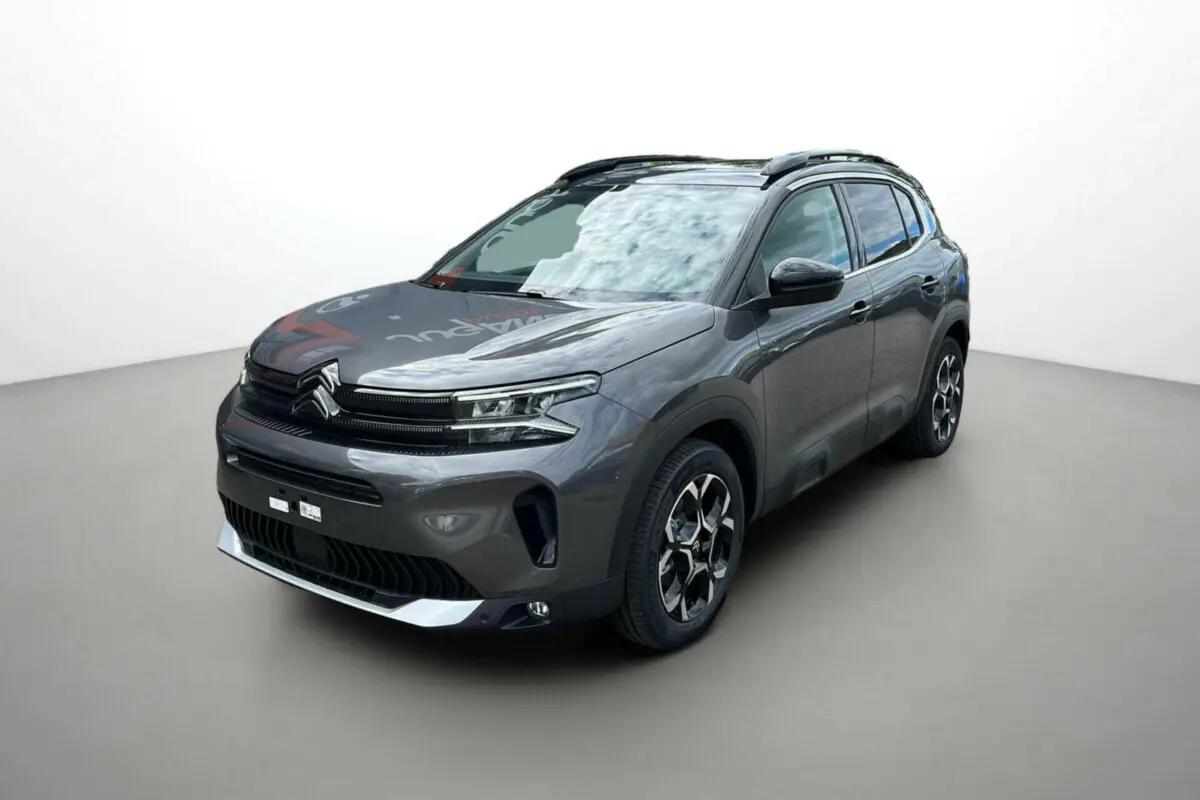 Citroën C5 Aircross Hybrid 2025 gris platinium avec toit noir, vue 3/4 avant mettant en valeur ses jantes distinctives.