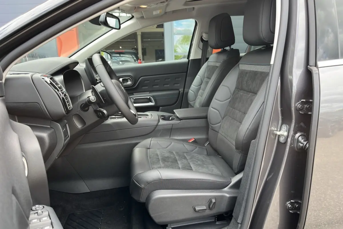 Intérieur du Citroën C5 Aircross Hybrid 2025, vue côté gauche, sièges cuir et alcantara gris avec tableau de bord moderne.