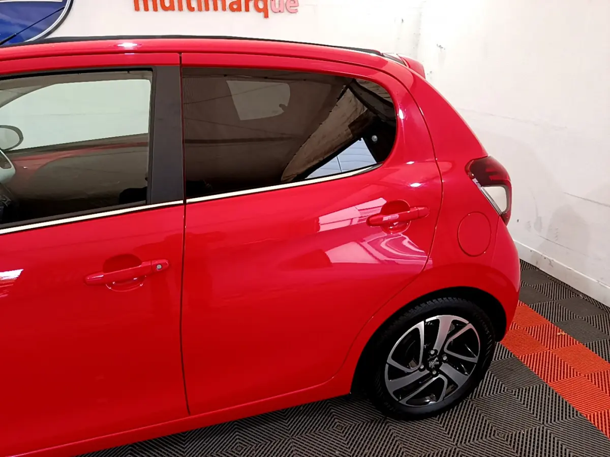 Vue latérale côté droit d'une Peugeot 108 rouge 2017 avec jantes alliage et toit ouvrant électrique en toile.