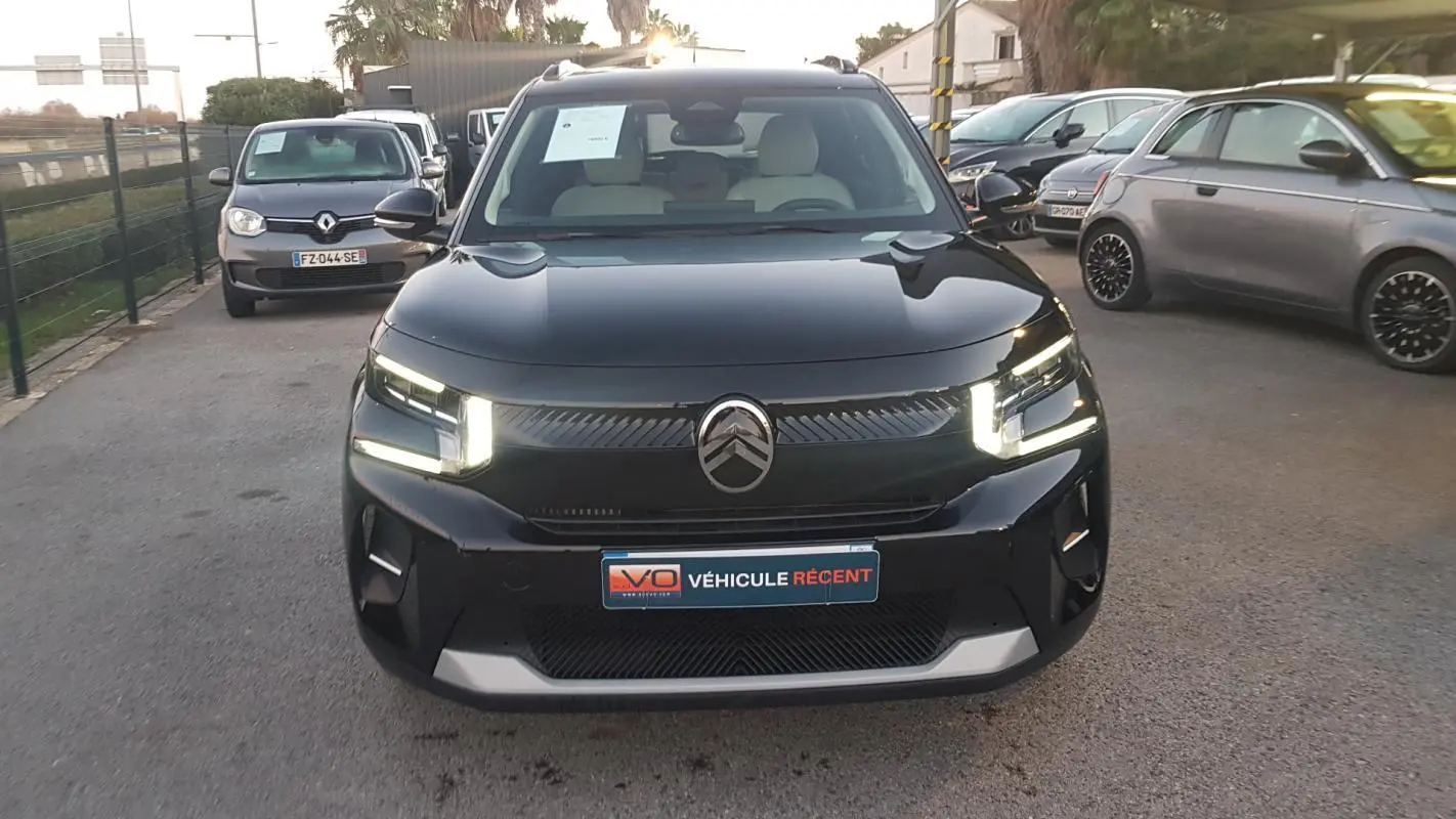 Vue avant d'une Citroën C3 noire 2025 avec feux LED en forme de C et barres de toit visibles.