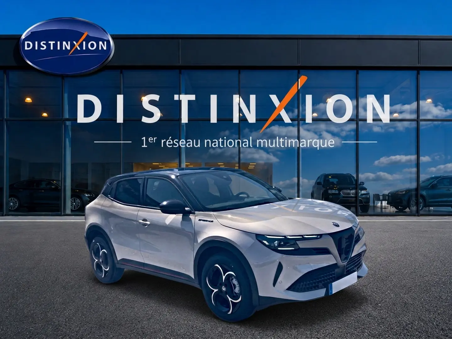 Alfa Romeo Junior 1.2 hybride 2026 vue 3/4 avant en ivoire et noir devant showroom Distinxion.
